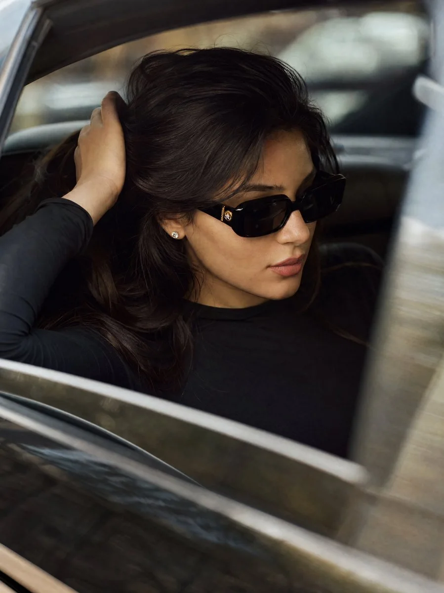 A backseat luxury editorial portrait variation with soft daylight, espresso hair, and blurred car interior bokeh.