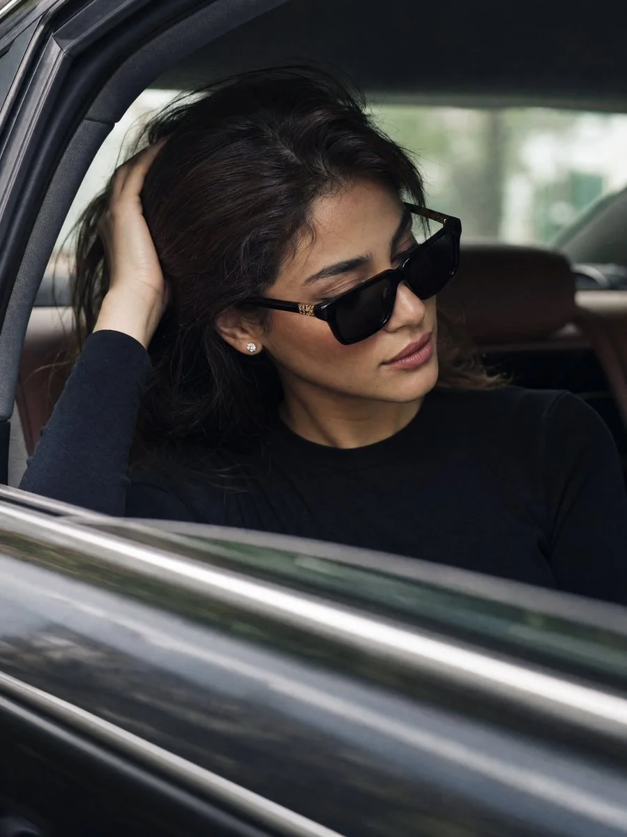 A paparazzi-style luxury portrait variation of a woman in a black crew-neck top inside a luxury automobile.
