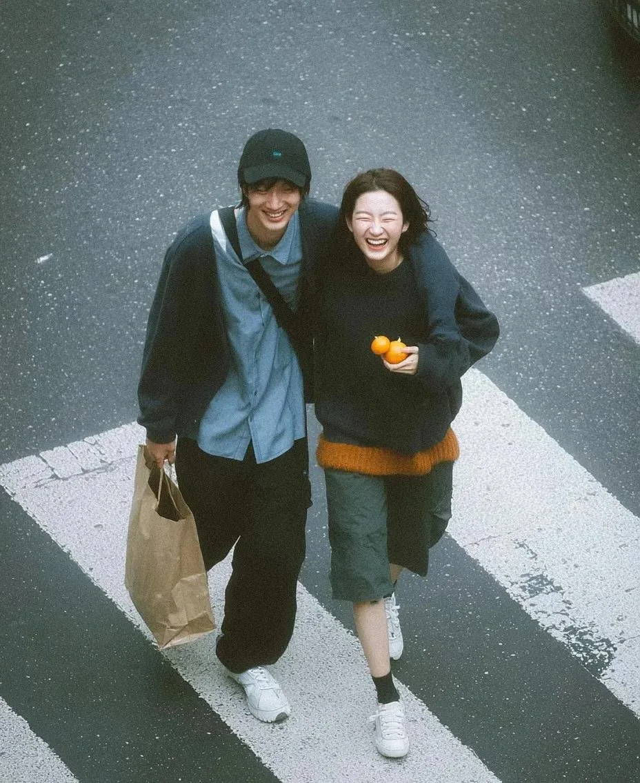 A cinematic high-angle zebra crossing couple photo variation with muted color grading and candid romantic lifestyle mood.